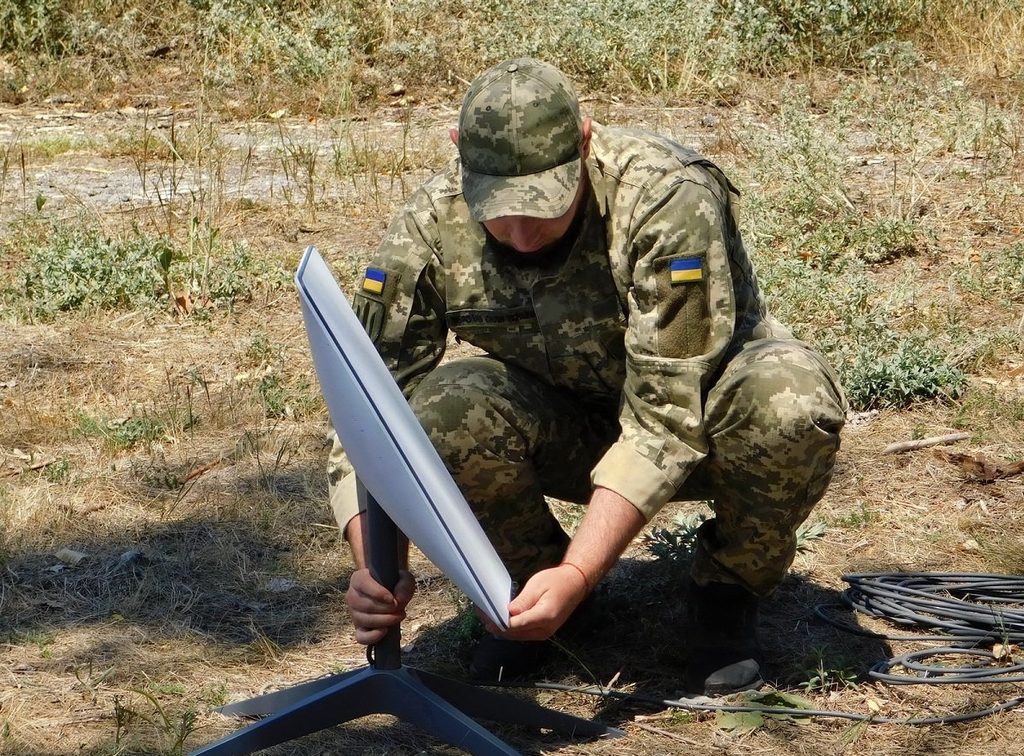 Солдат ВС Украины устанавливает терминал "Старлинк".